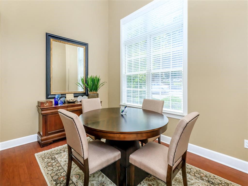 a dining room with a table and chairs and a window