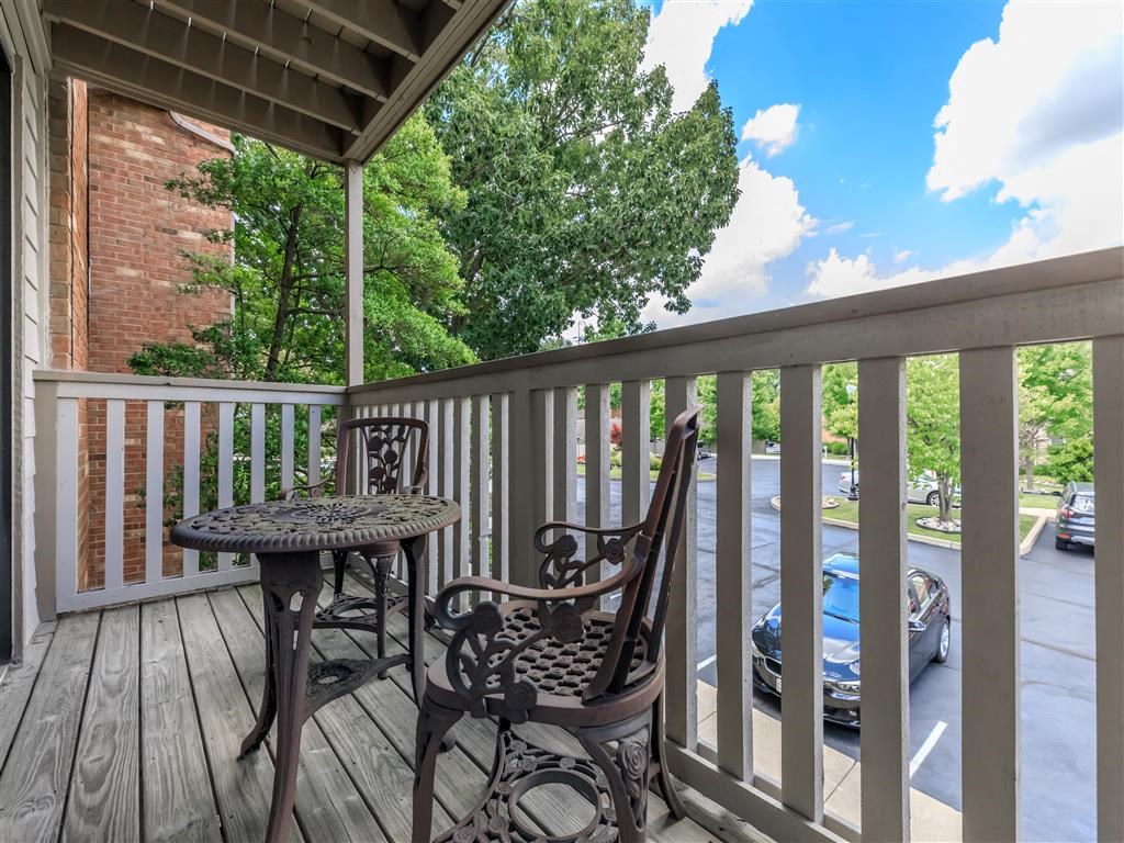 a patio with two chairs and a table on a balcony