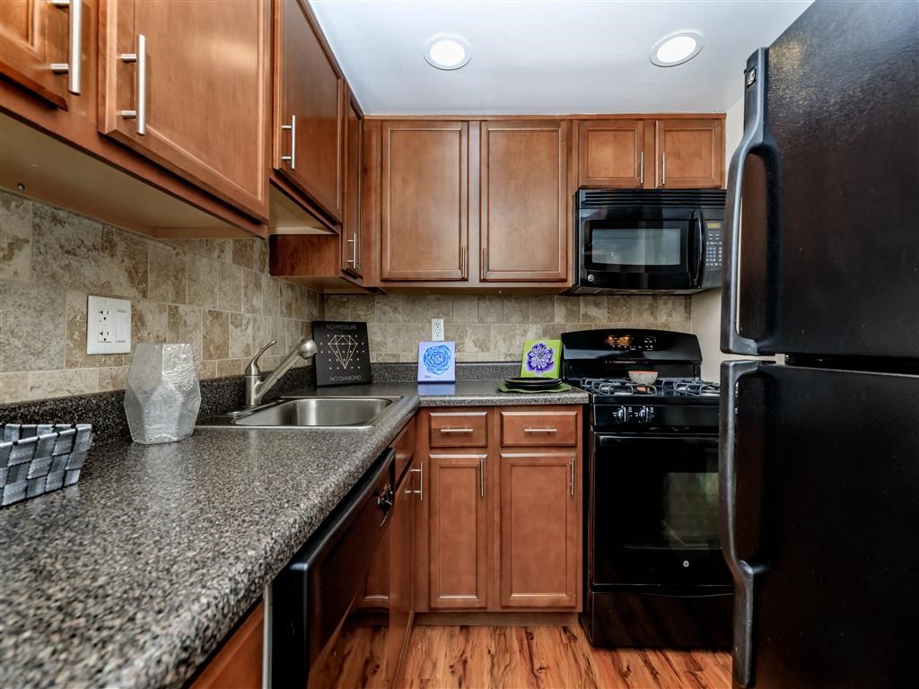 a kitchen with granite counter tops and black appliances