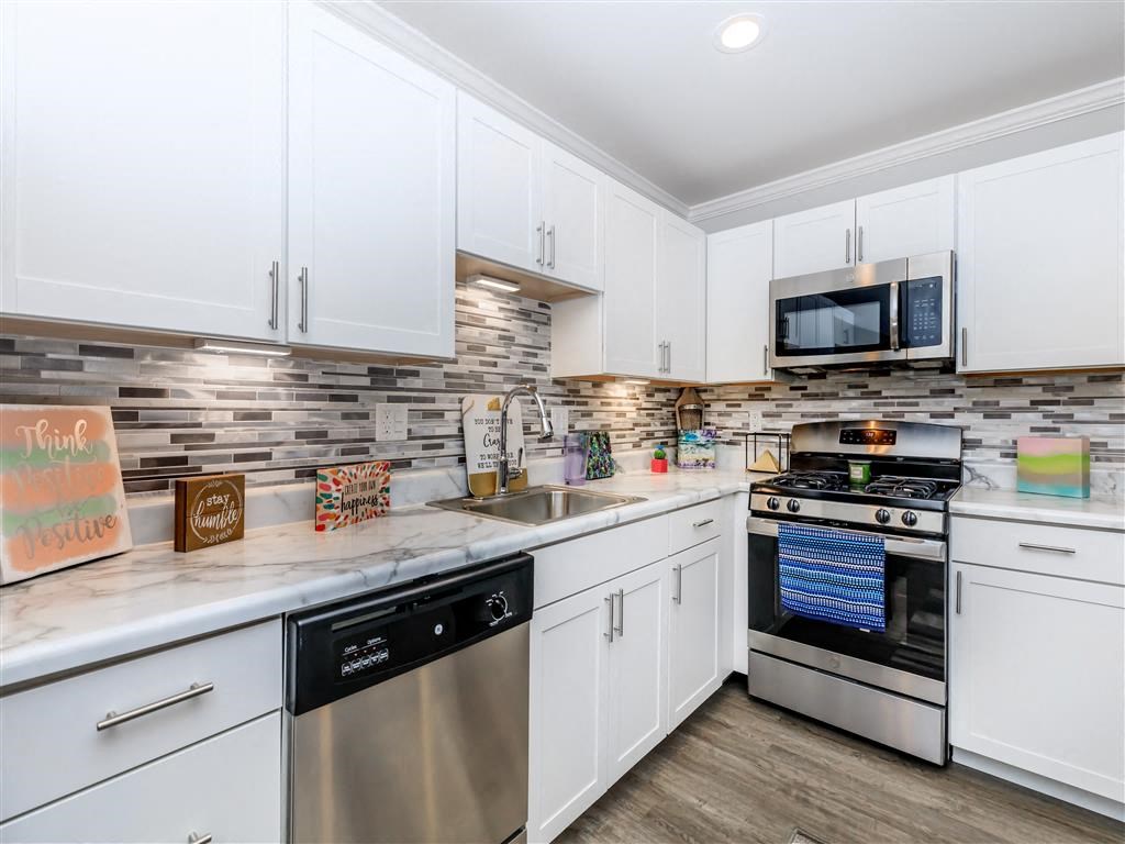 a kitchen with stainless steel appliances and white cabinets