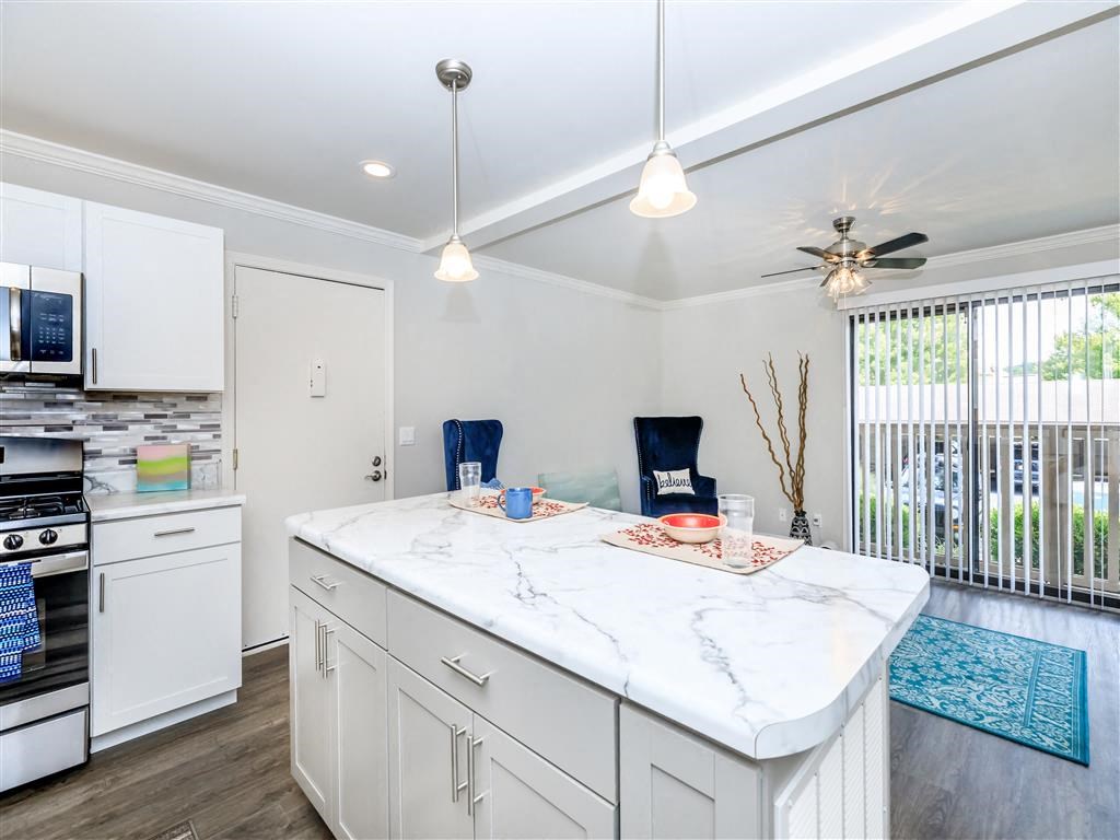 a white kitchen with a large island and a window