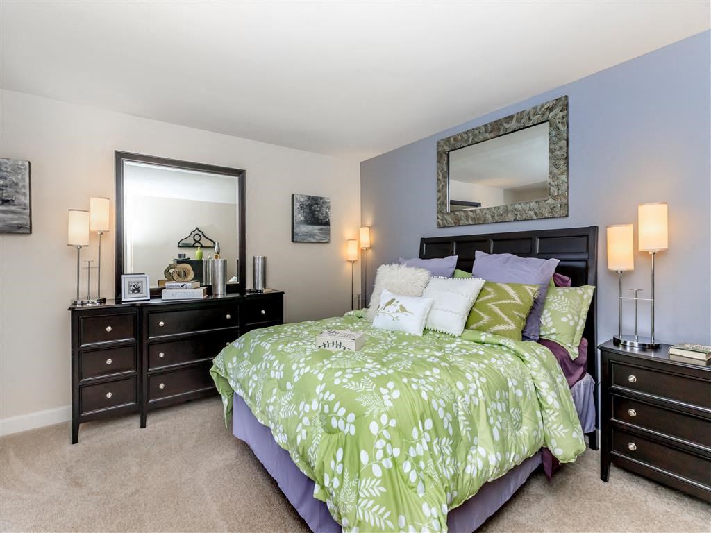 a bedroom with a bed and two dressers