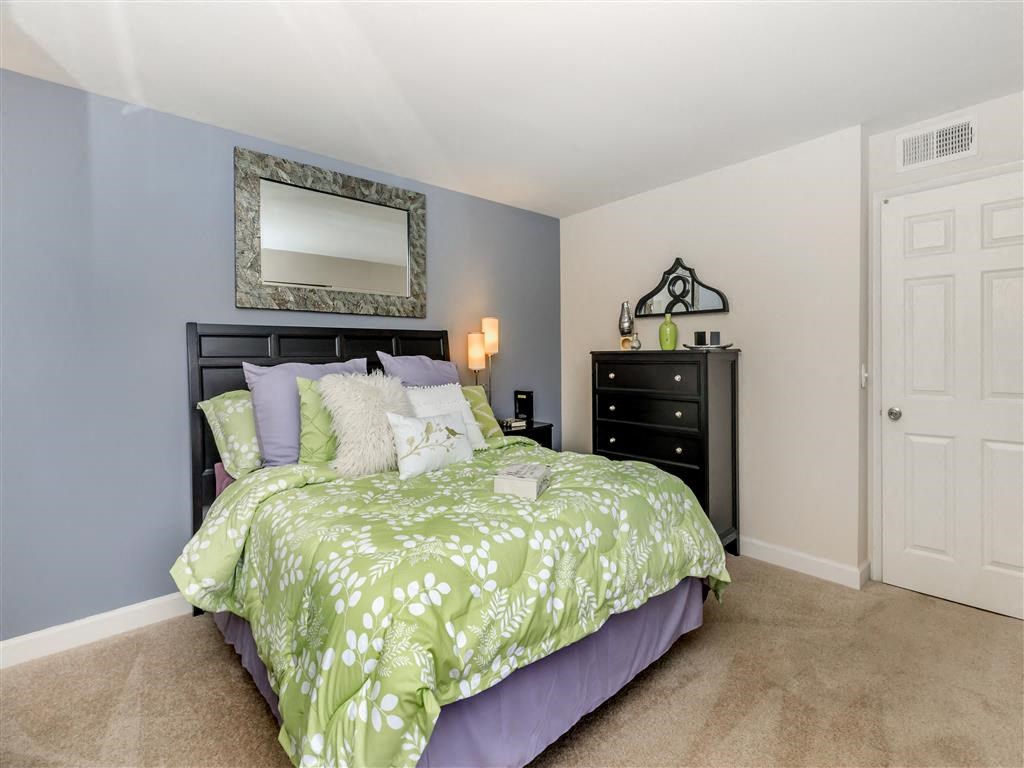 a bedroom with a bed and a mirror