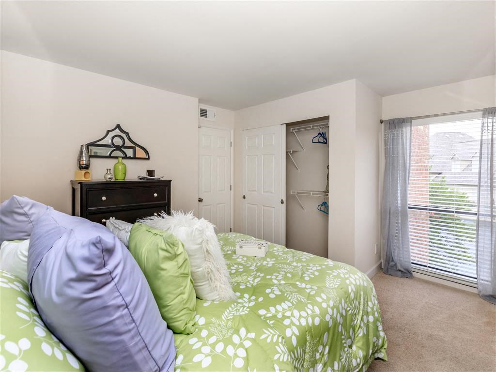 a bedroom with a bed and a door to a closet