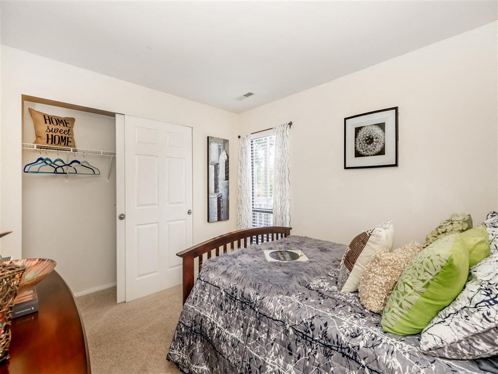 a bedroom with a bed and a door to a closet