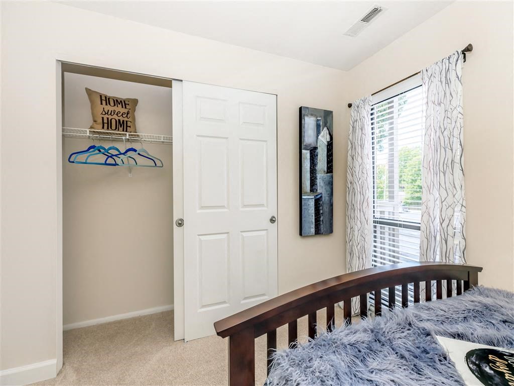 a bedroom with a bed and a closet and a window