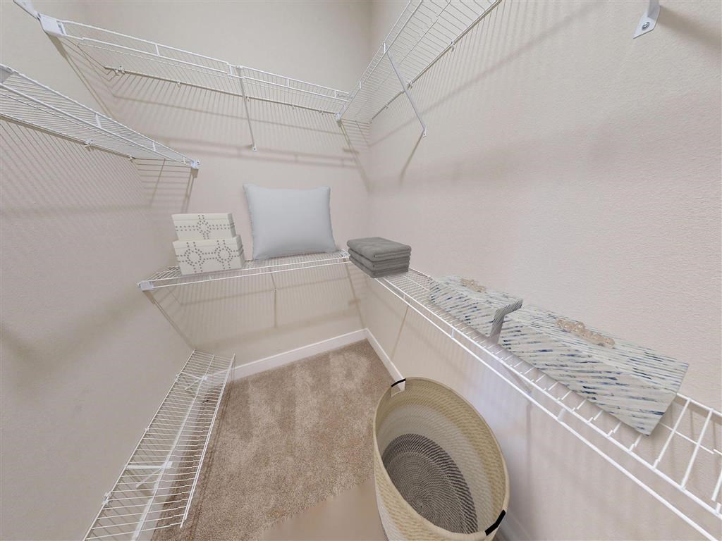 a walk in closet with a bed and a fan