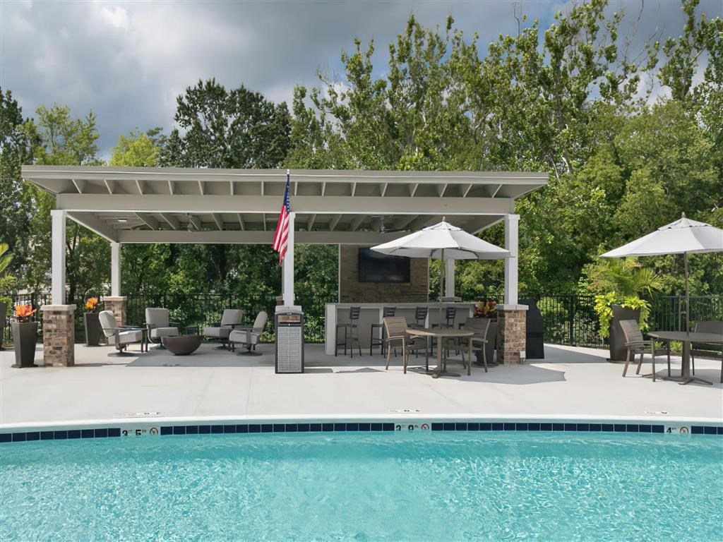 a poolside pavilion with an outdoor entertaining area and a swimming pool