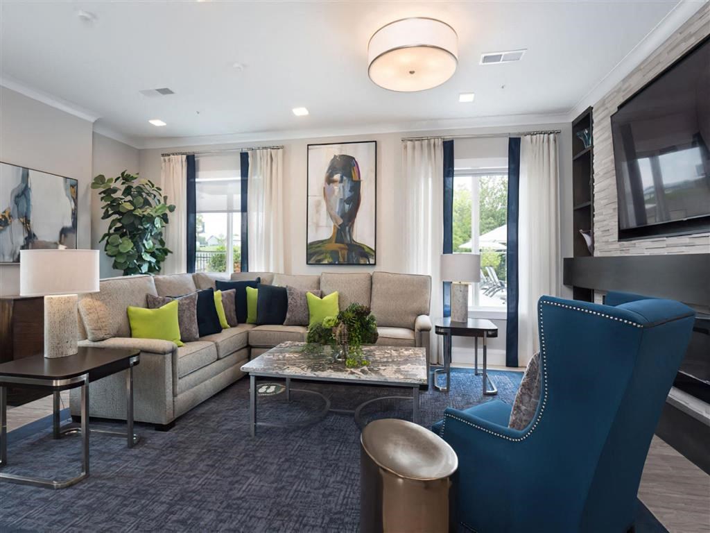 a living room with a couch and chairs and a television