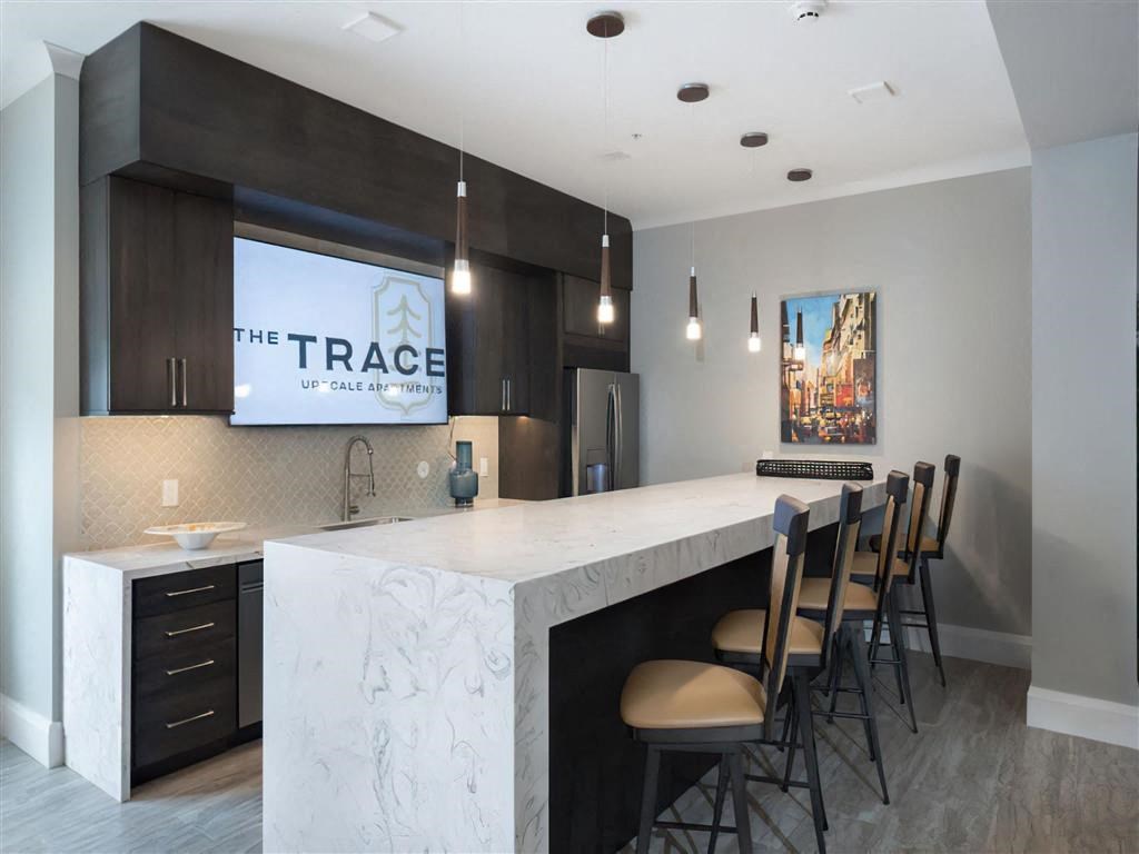 a large kitchen with a marble counter top and chairs