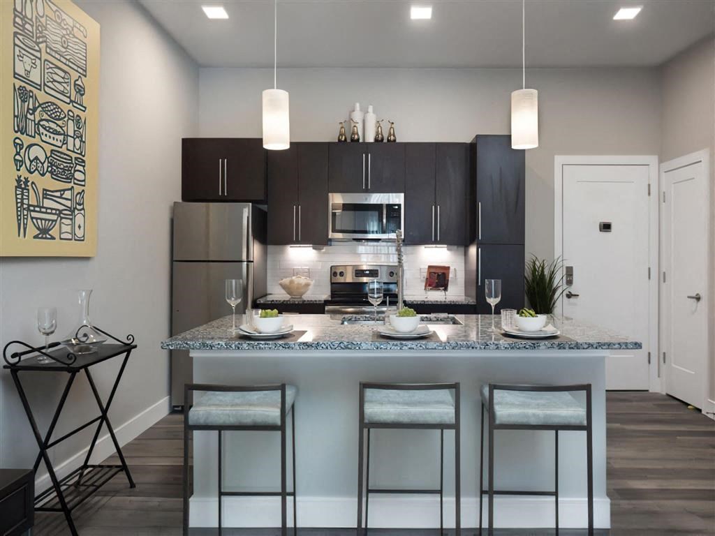 a kitchen with a counter top with three stools