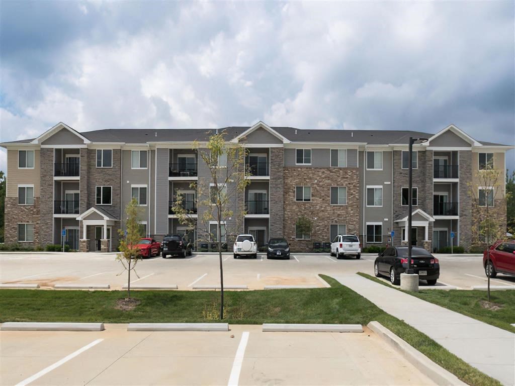 an apartment building in a parking lot with cars