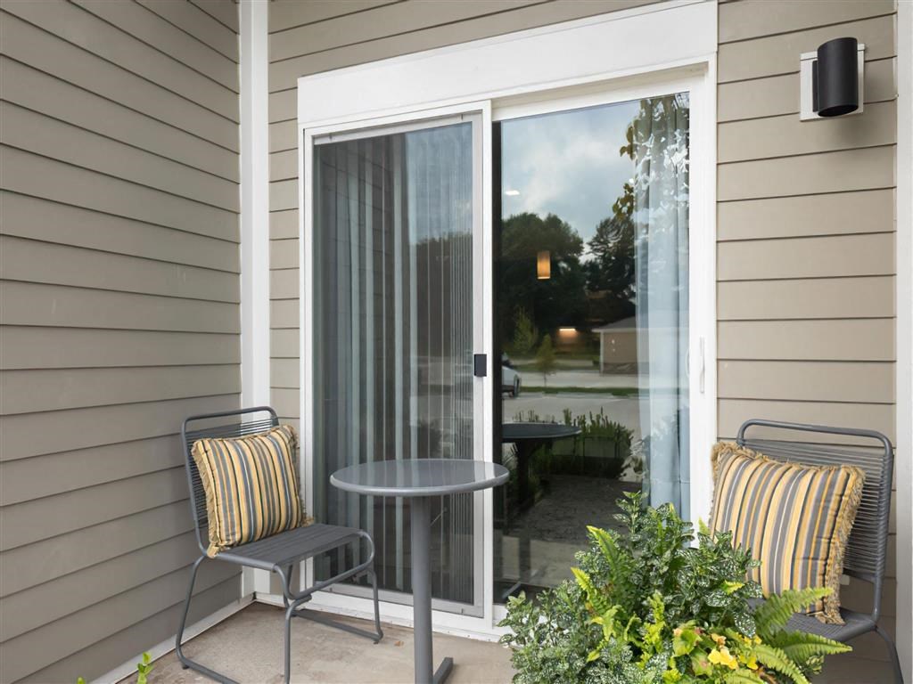 a patio with a table and chairs outside of a window