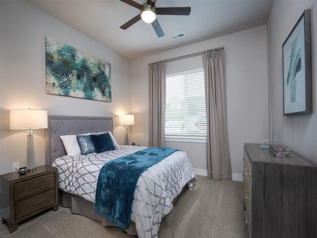 a bedroom with a bed and a ceiling fan