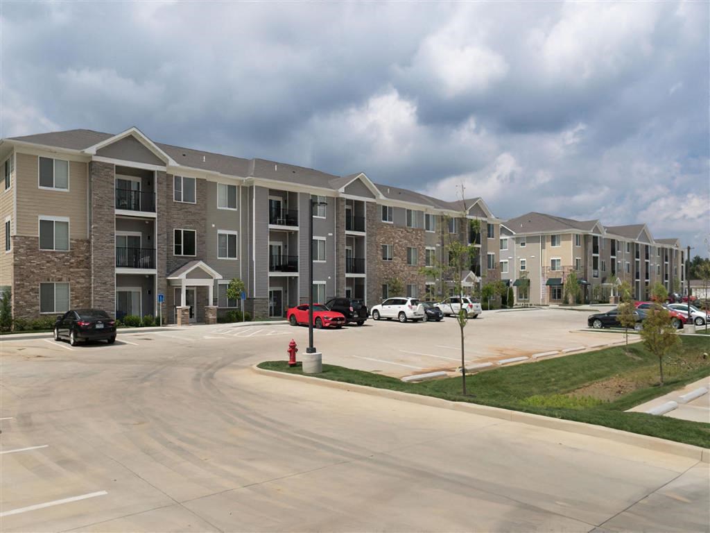 an empty parking lot in front of an apartment building