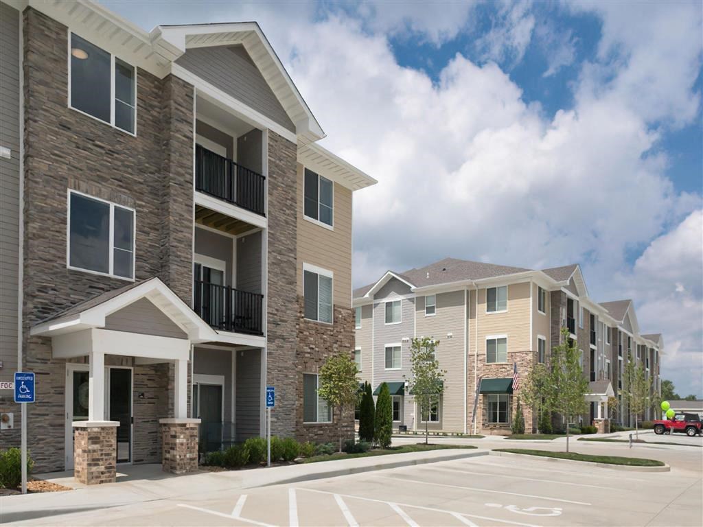 an empty parking lot in front of an apartment building