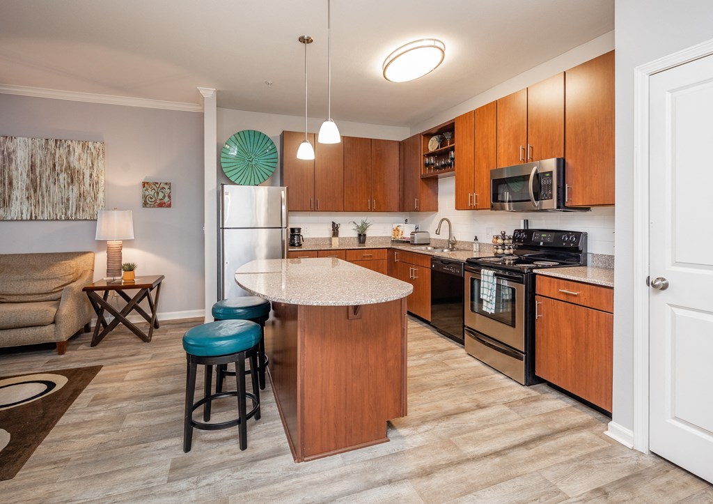 A kitchen with a white island and blue stools.