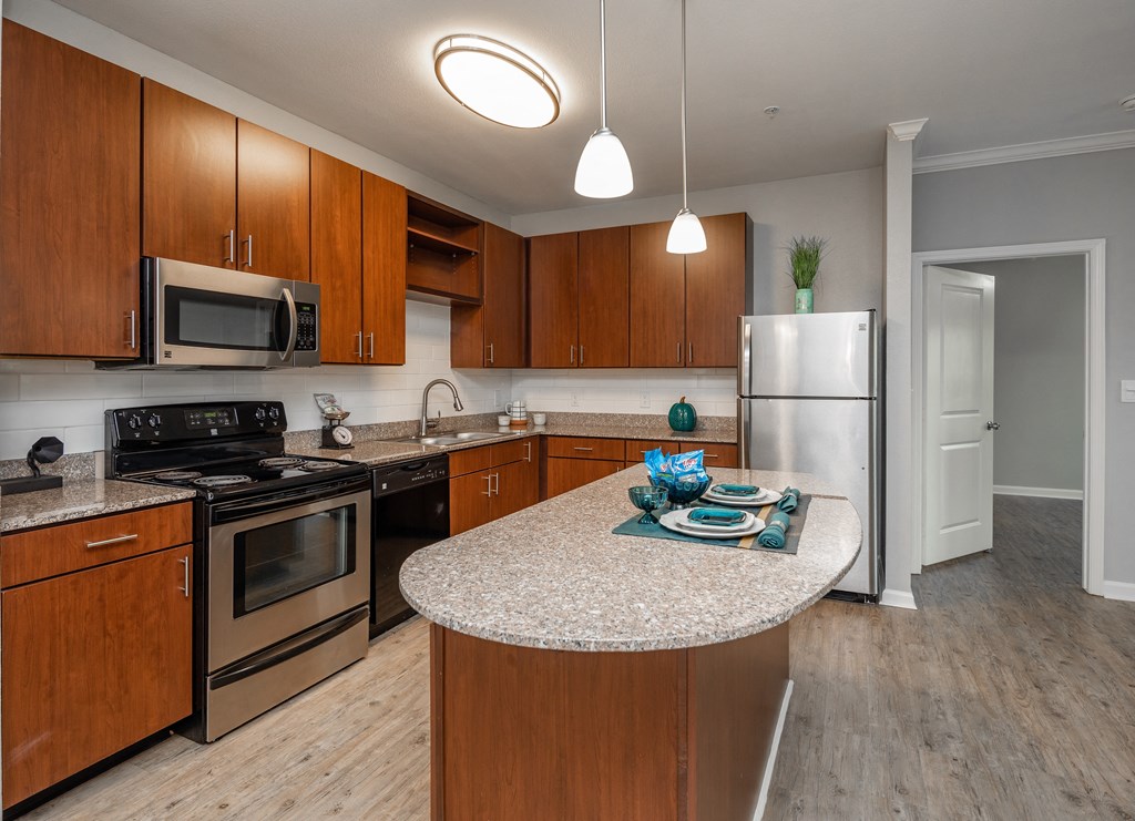 A kitchen with wooden cabinets and a granite countertop.