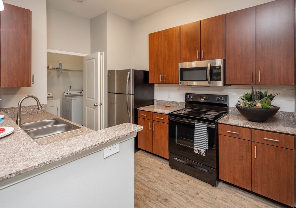 A kitchen with a black oven and wooden cabinets.