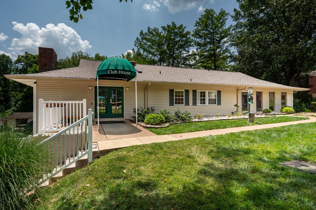 a white house with a green umbrella on the front porch