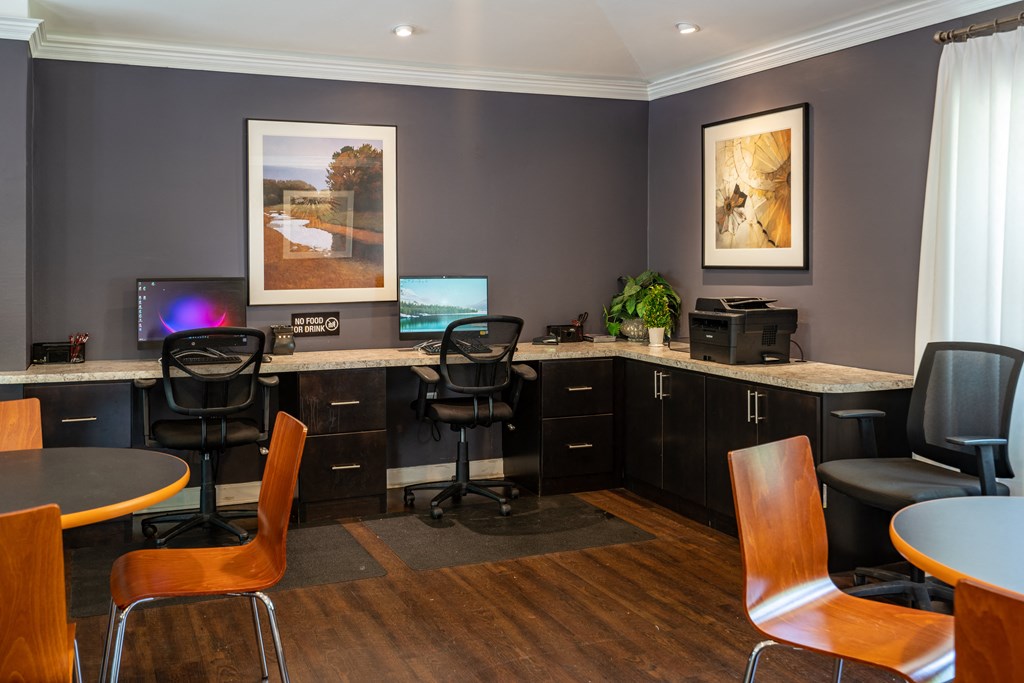 an office with two desks and chairs and two computers