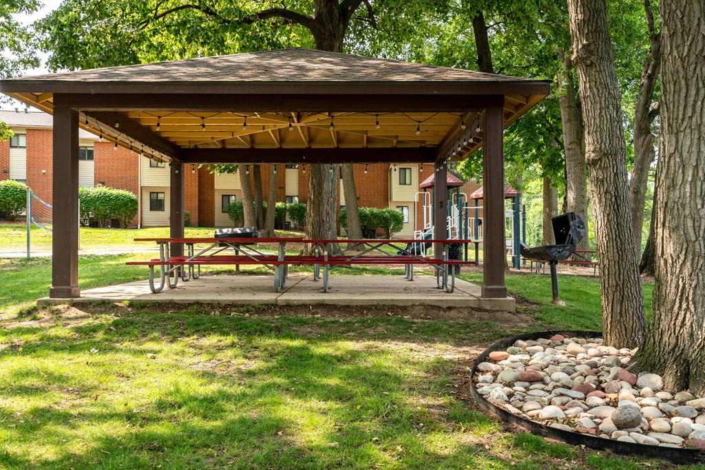 a gazebo with a picnic table and a fire pit