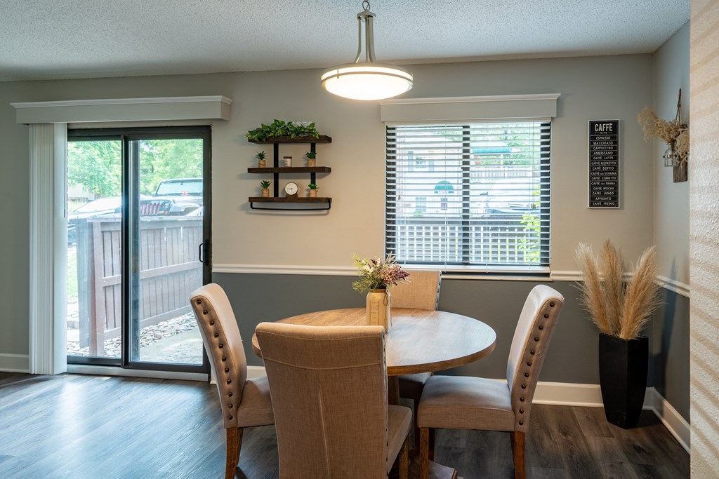 a dining room with a table and chairs and a sliding glass door