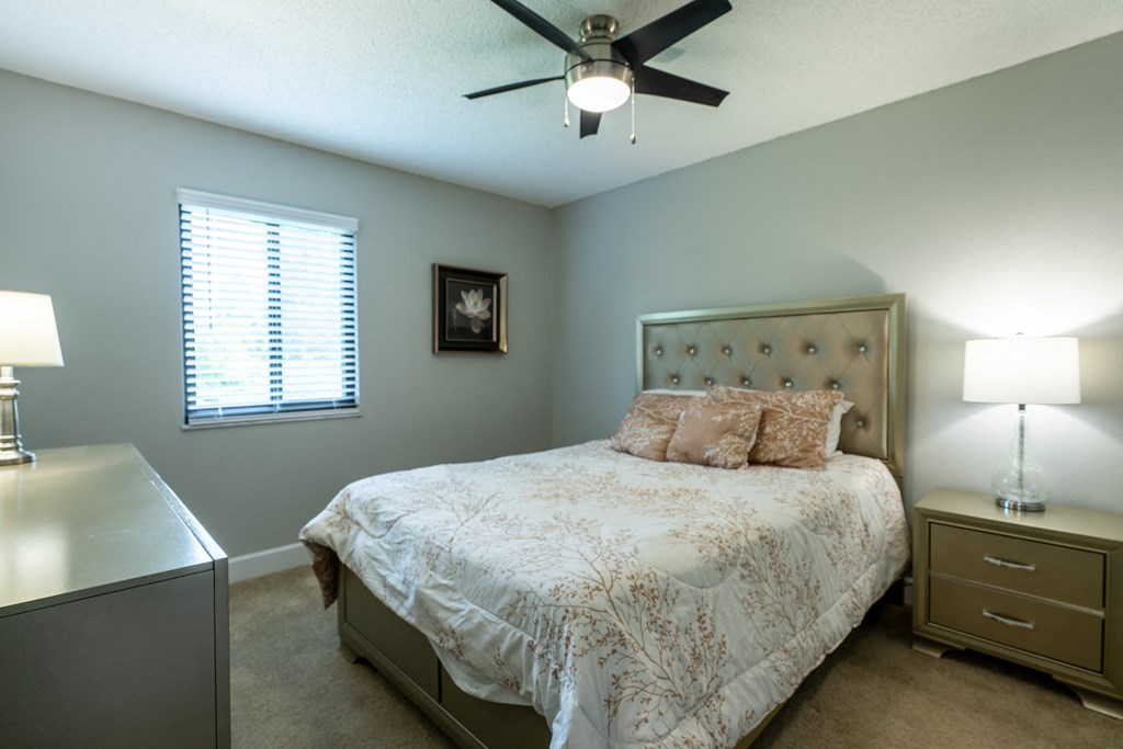 a bedroom with a bed and a ceiling fan