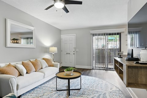 A living room with a white couch and a round table in the center.