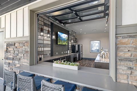A modern kitchen with a bar area and a dining table set up.