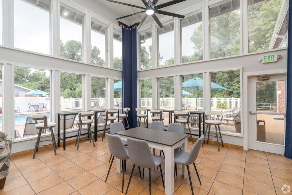 A dining room with a table and chairs and a ceiling fan.