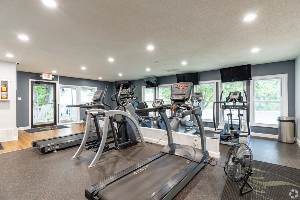 A gym with treadmills, elliptical machines, and other exercise equipment.