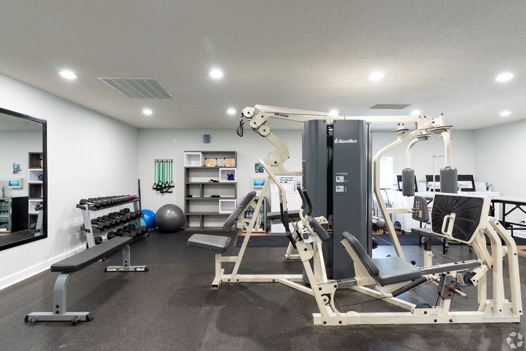 A well-equipped gym with a mirror on the wall.