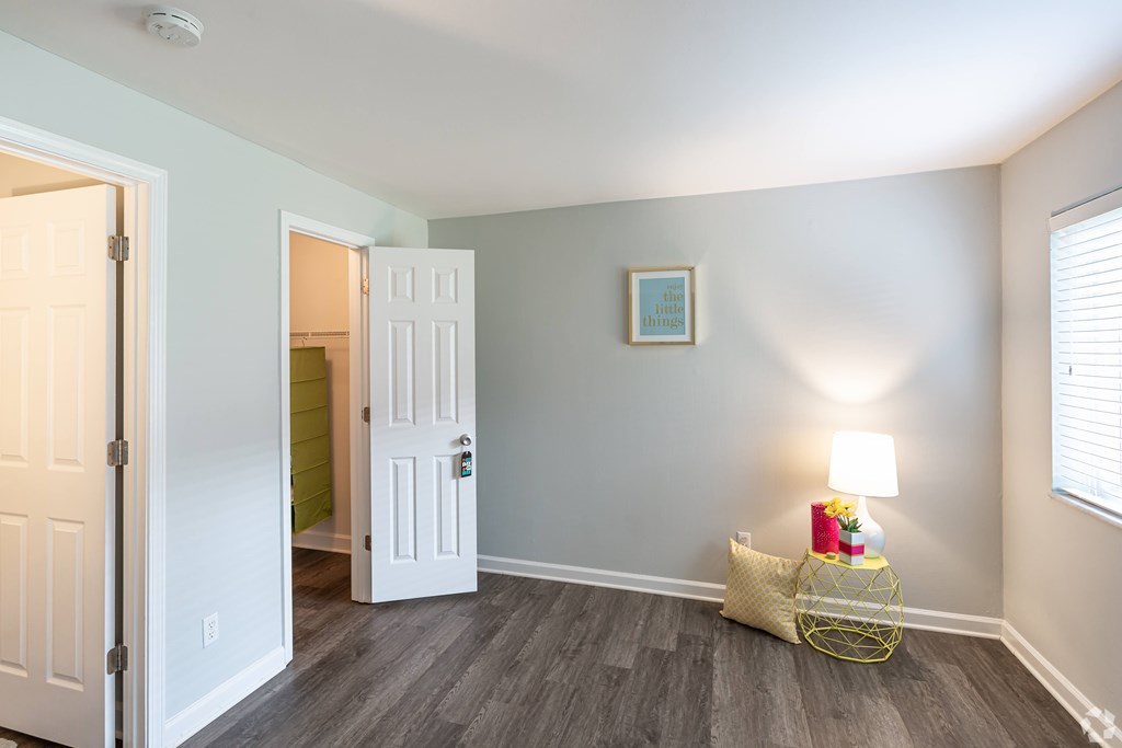 A room with a white door and a yellow basket on the floor.