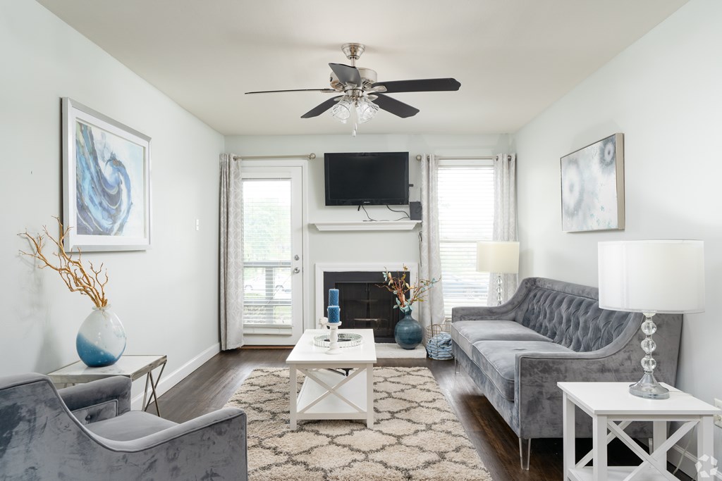 A living room with a grey couch, a white coffee table, and a fireplace.