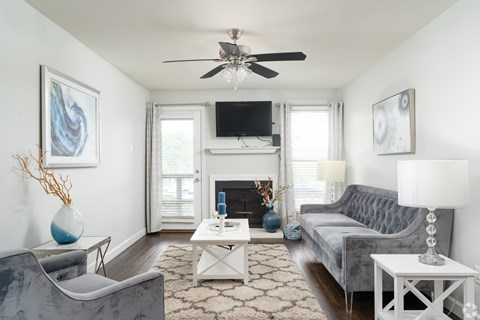 A living room with a grey couch, a white coffee table, and a fireplace.