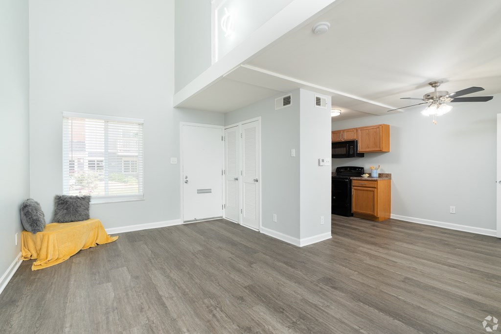 A room with a ceiling fan and a window with blinds.