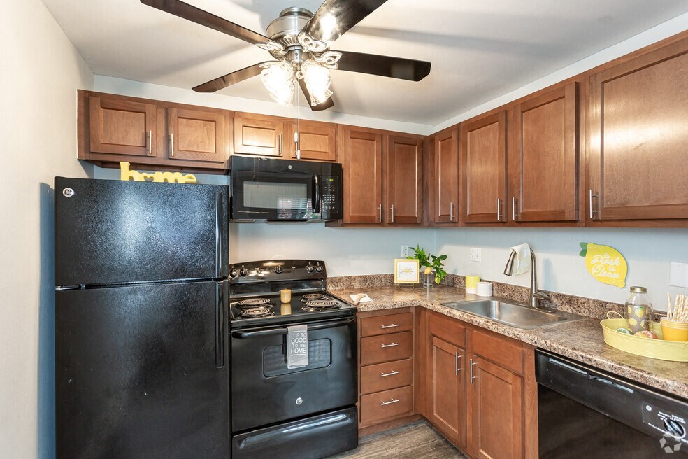 a kitchen with black appliances and wood cabinets