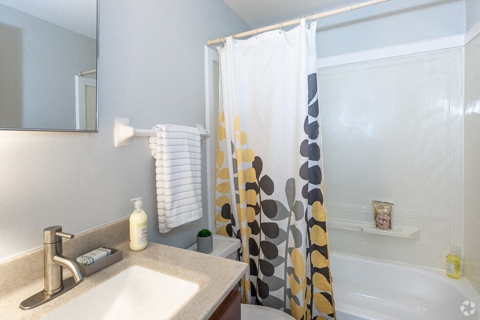 a bathroom with a shower and a sink and a shower curtain