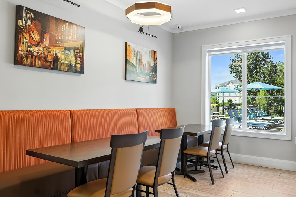 A room with a table and chairs and two pictures on the wall.