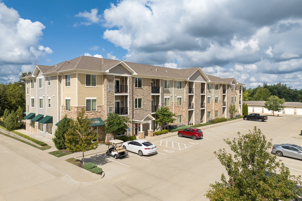 A large apartment complex with a parking lot in front.