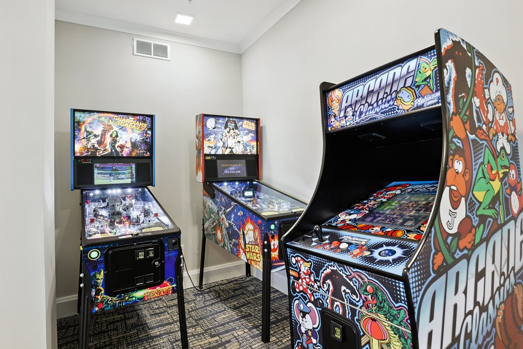 Two pinball machines are on display in a room.