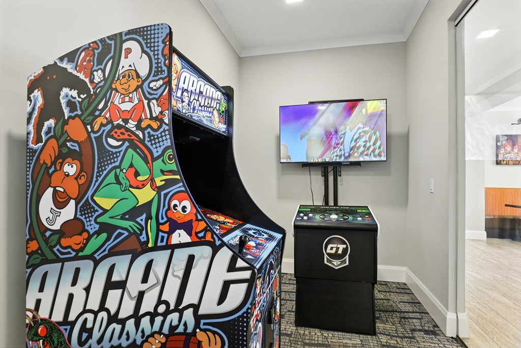 A small indoor play area with a TV and a large arcade machine.