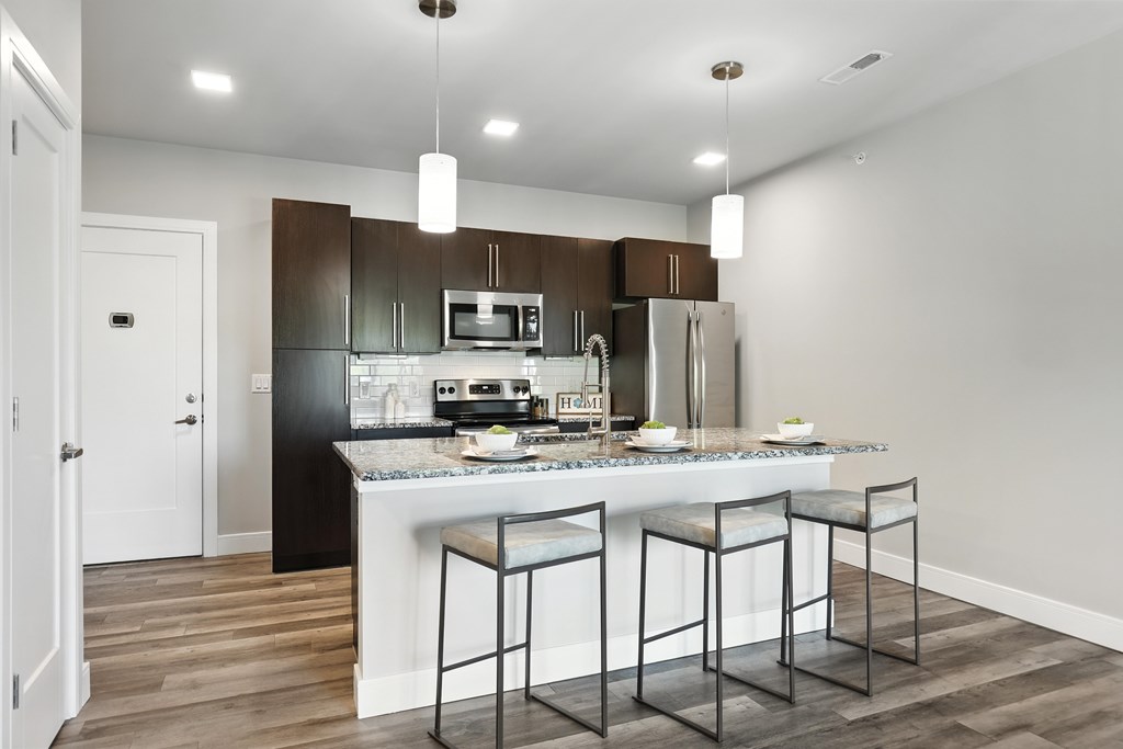 A kitchen with a bar stool in front of it.