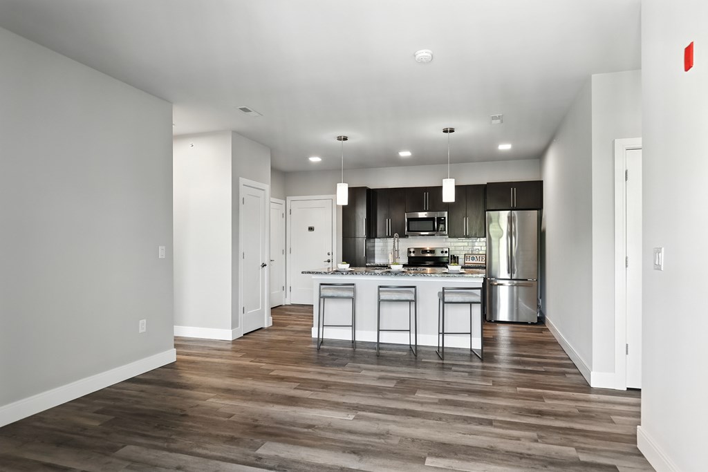 A kitchen with a refrigerator, stove, and sink.