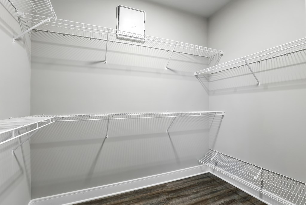 Empty white shelves in a room with a small window.