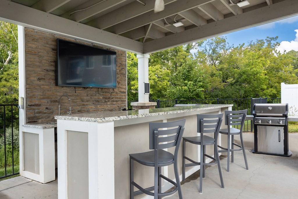 A patio with a bar and chairs.