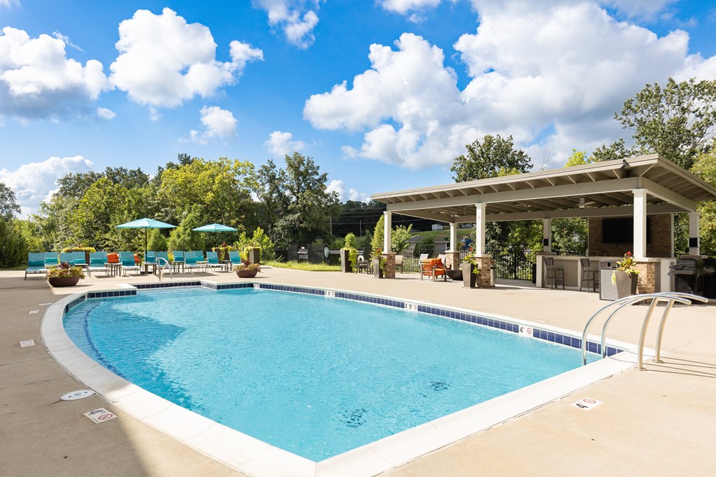 A large outdoor swimming pool with a pavilion and sun loungers.