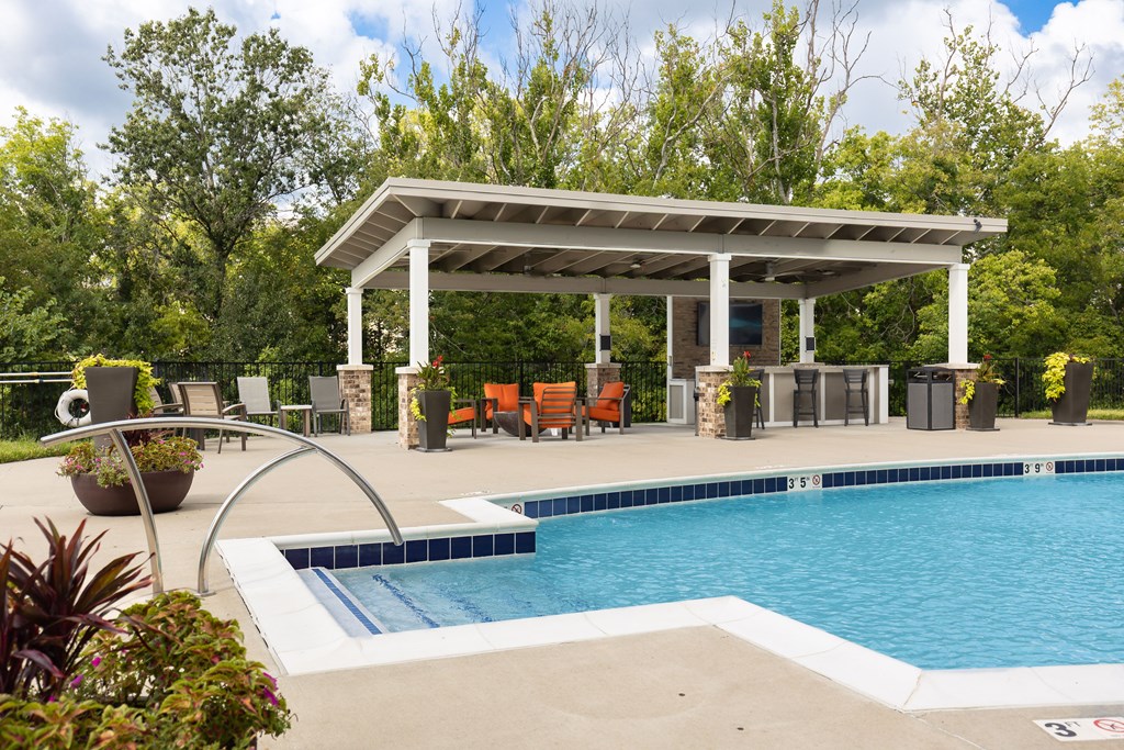 A pool with a white canopy and a hot tub.