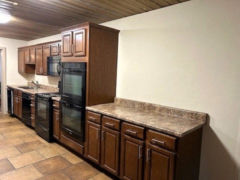 a kitchen with granite counter tops and black appliances